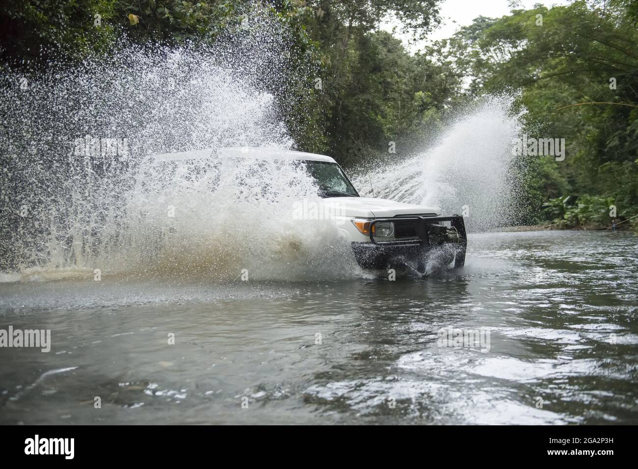 Un veicolo safari spruzza attraverso un fiume che attraversa la foresta pluviale Costa Rica sulla penisola di Osa; Puntarenas, Costa Rica Foto Stock