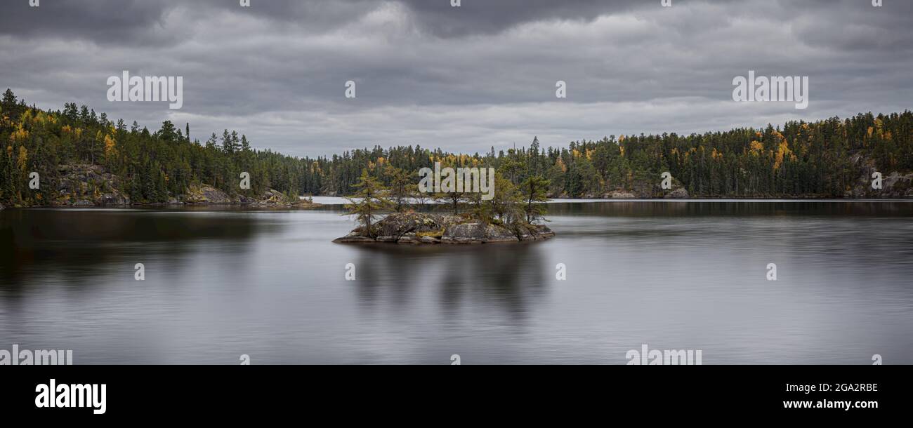 Autunno foresta colorata e fiume sotto un cielo sovrastato nel nord Ontario; Thunder Bay, Ontario, Canada Foto Stock