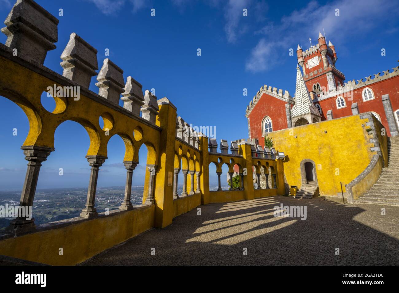 Affacciato su Sintra attraverso i colorati archi e colonne della Queen's Terrace con la Torre dell'Orologio rossa sullo sfondo del Palacio da pena Foto Stock