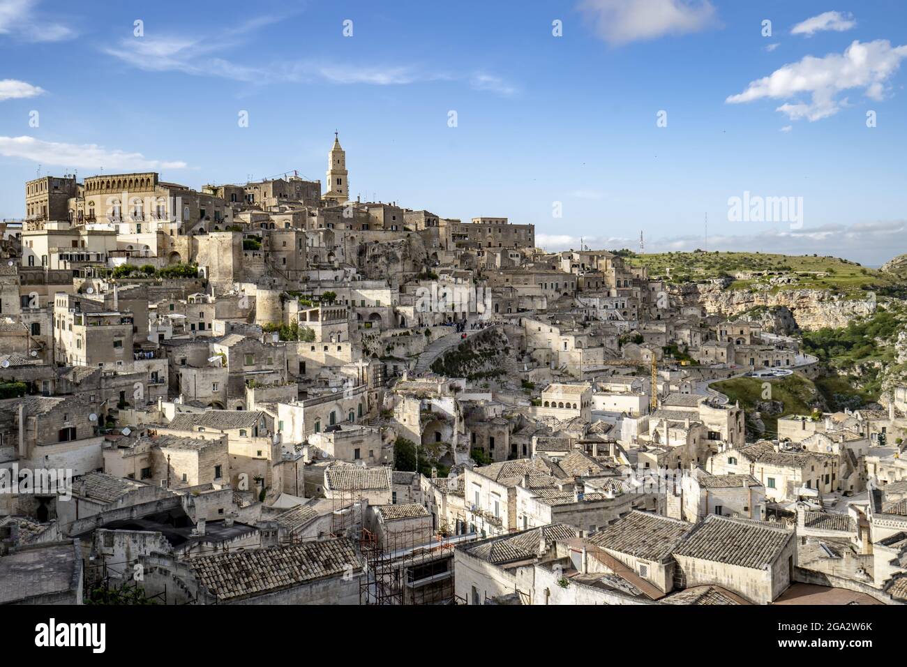 Paesaggio urbano della città montagnosa di Sassi di Matera e delle sue antiche abitazioni rupestri con il campanile della Cattedrale di Matera che si affaccia sulla città Foto Stock