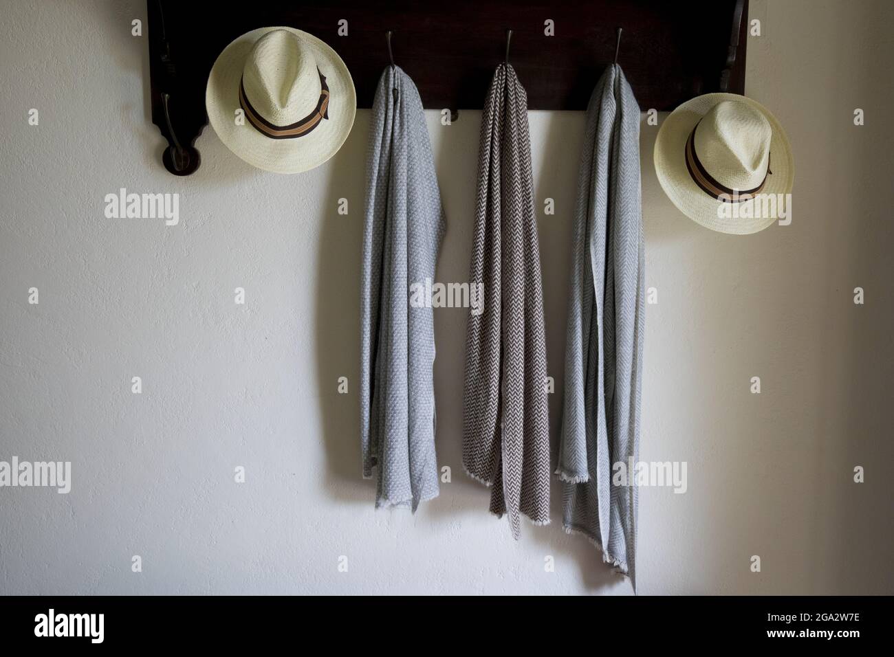 Cappelli e pashminas su un appendiabiti su una parete in Nine Skies Bungalow boutique hotel a Demodra, Hill Country, Sri Lanka Foto Stock