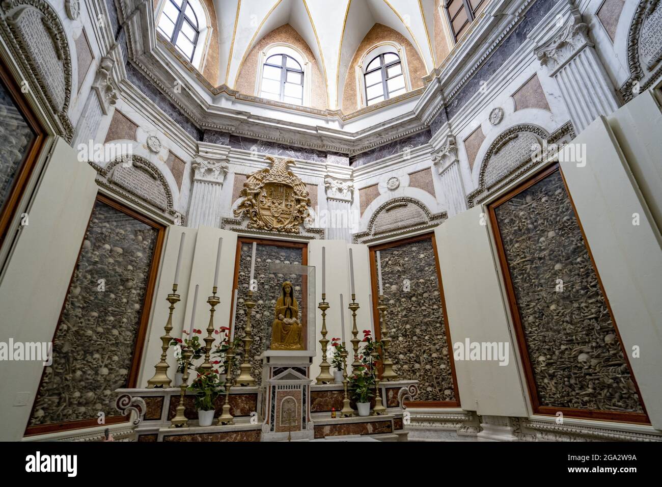 Cappella dei Martiri con una statua della Madonna e del Bambino seduta sopra l'altare e cripte vetrata nel muro contenente i resti di OT... Foto Stock