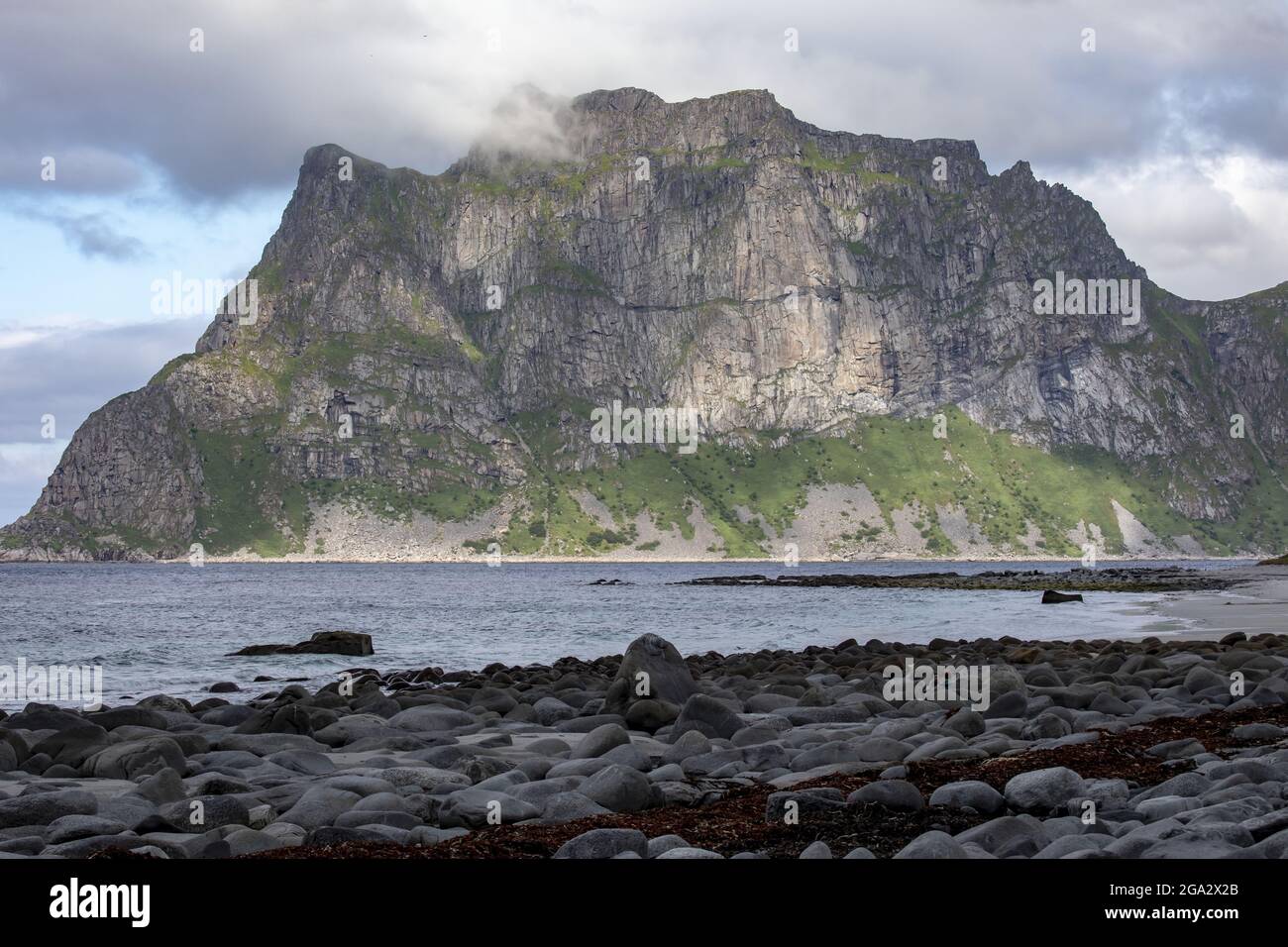 Il suggestivo paesaggio costiero di montagna e roccia di Utttakleiv Beach; Lofoten, Norvegia Foto Stock