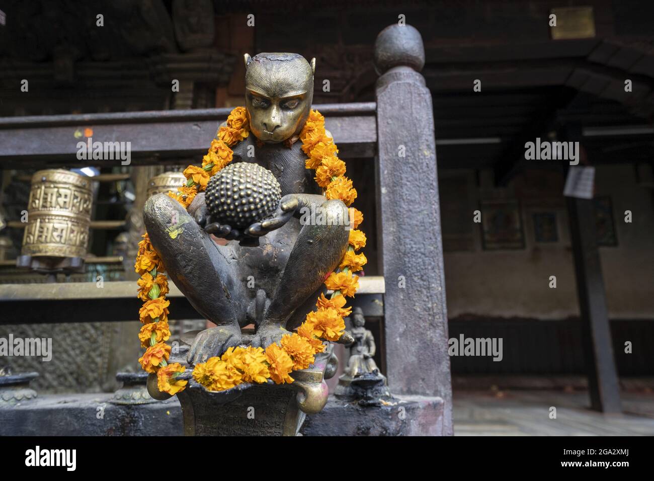 Figura di scimmia di ottone decorata con ghirlanda di fiori nel Tempio d'oro di Kwa Bahal nella città vecchia di Patan o Lalitpur costruito nel XII secolo da K... Foto Stock