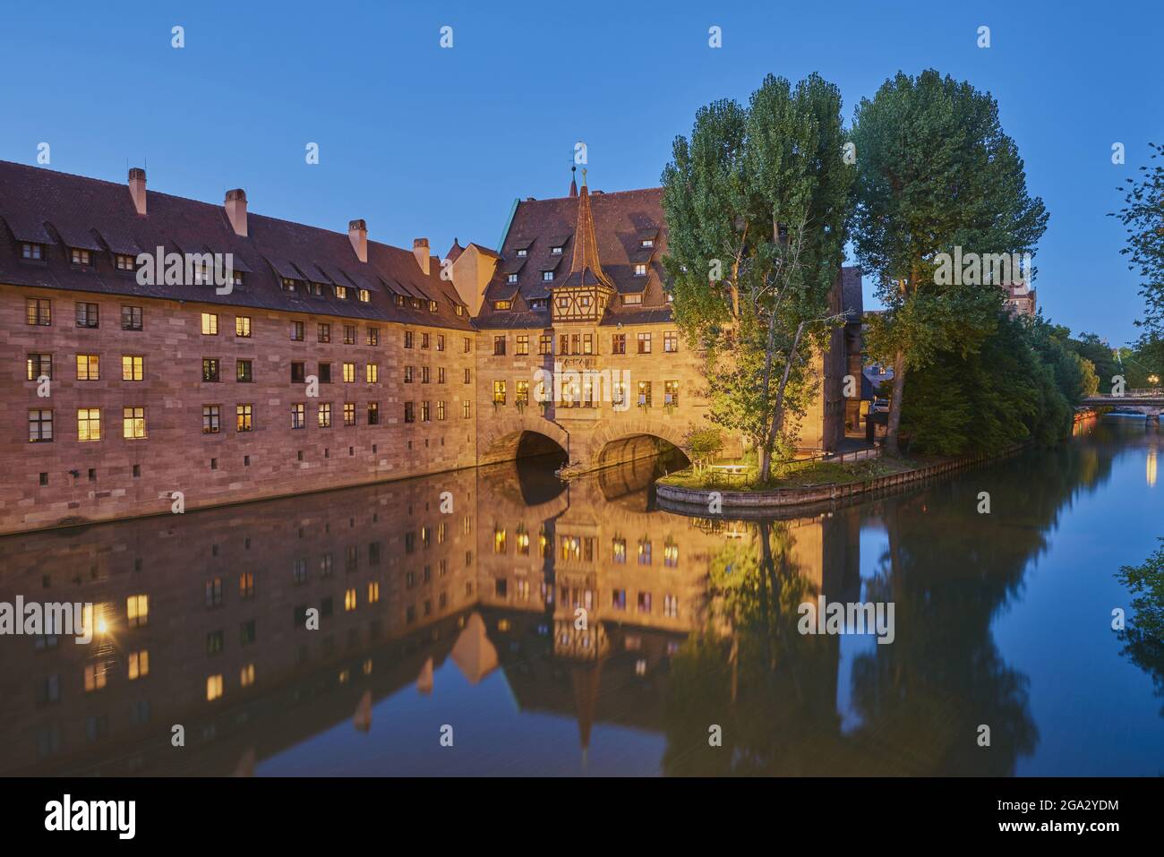 Il fiume Pegnitz attraversa Norimberga all'ora blu con l'Heilig-Geist-Spital (ospedale dello Spirito Santo) nella città vecchia; Franconia, Baviera, Germania Foto Stock