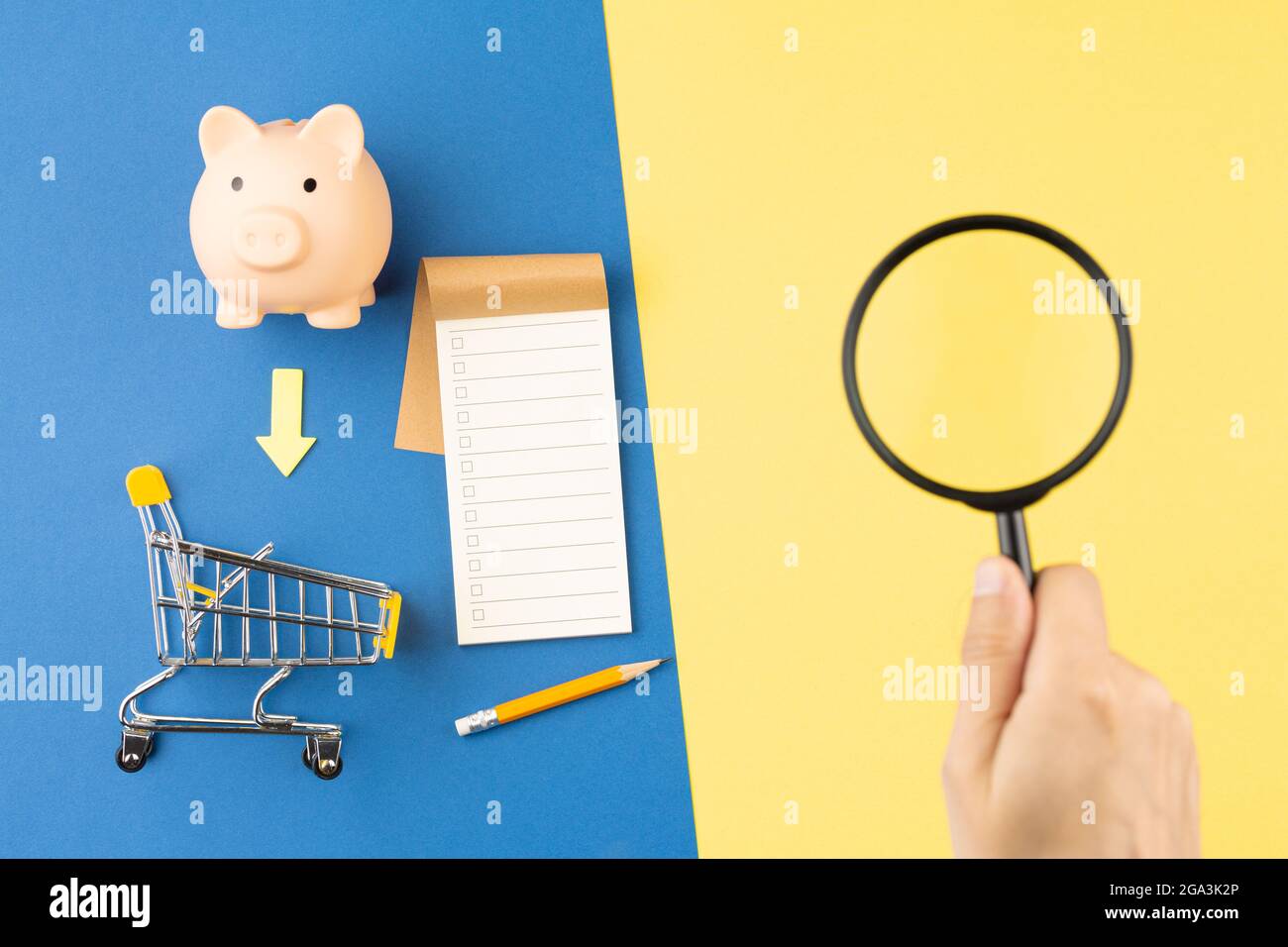 Banco di piggy con lente di ingrandimento a carrello e blocco note. Foto Stock