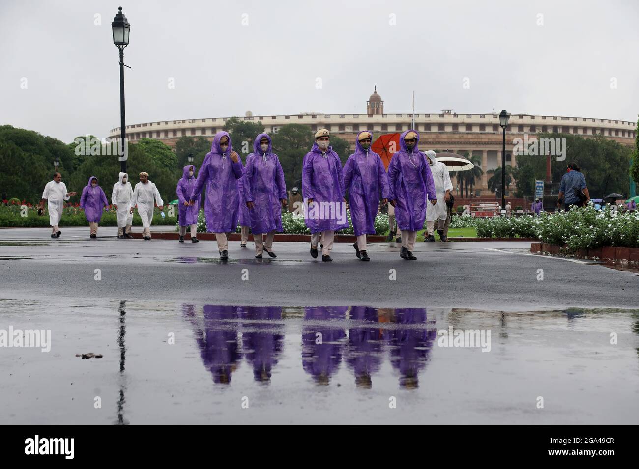 Nuova Delhi, India. 28 luglio 2021. Il personale della polizia di Delhi indossa maschere facciali e cappotti a pioggia mentre è in servizio a Vijay Chowk durante la pioggia monsonica. Le forti piogge hanno causato il disboscamento delle acque sulla strada nella capitale nazionale. (Foto di Naveen Sharma/SOPA Images/Sipa USA) Credit: Sipa USA/Alamy Live News Foto Stock