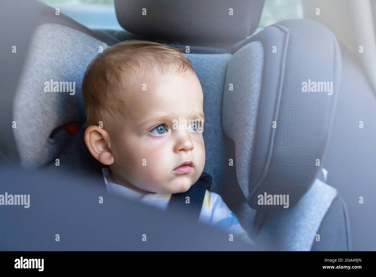 Il bambino nel seggiolino per auto osservata attraverso il sedile
