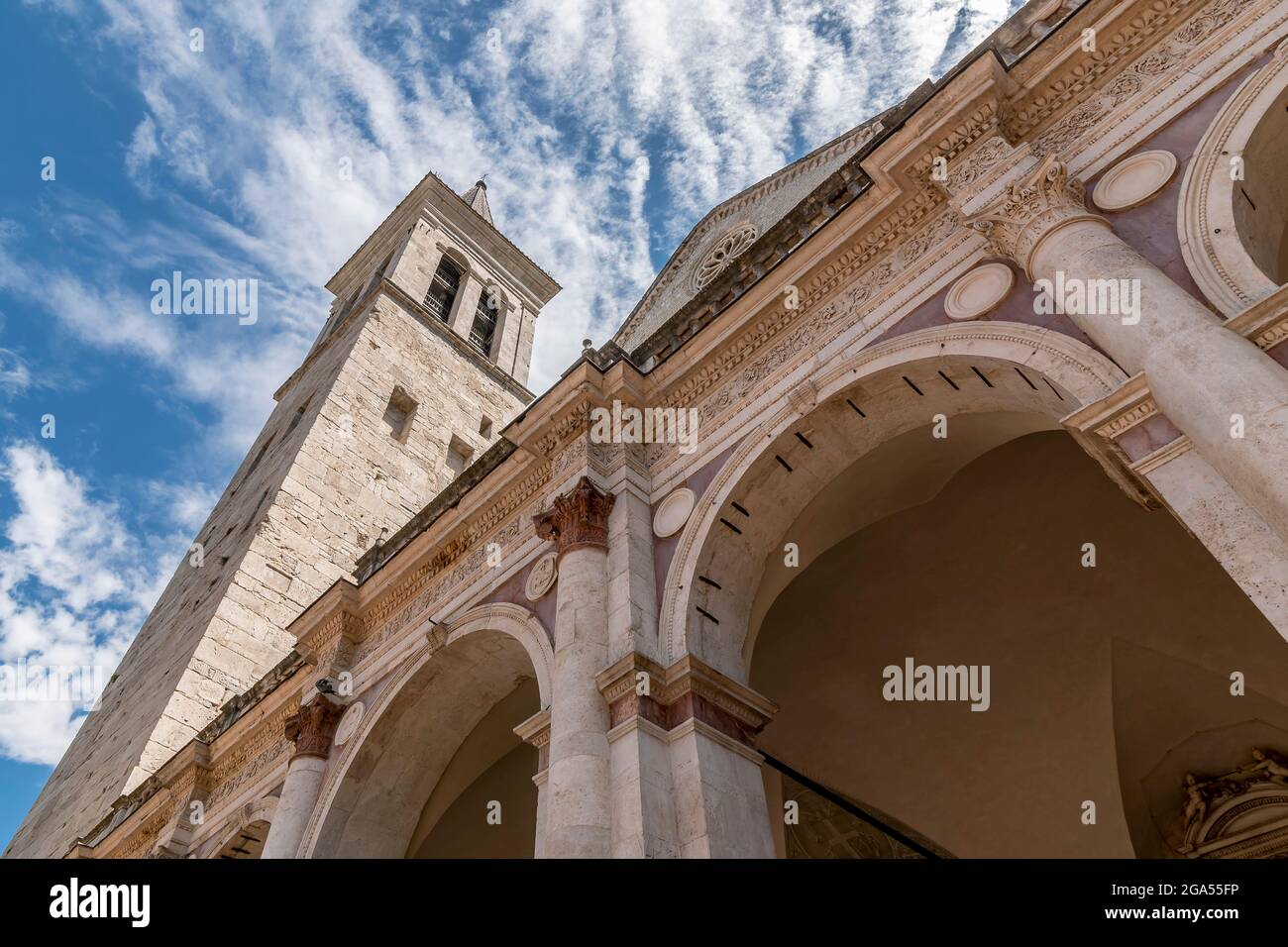 Particolare dal basso della facciata dell'antico Duomo di Santa Maria Assunta a Spoleto, in Italia, contro un cielo drammatico Foto Stock