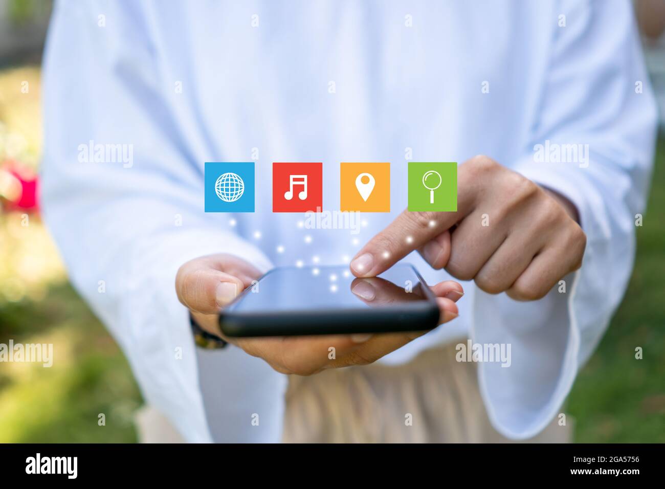 Le icone di intrattenimento vengono visualizzate sulla mano della donna utilizzando lo smartphone per rilassarsi e divertirsi. Foto Stock