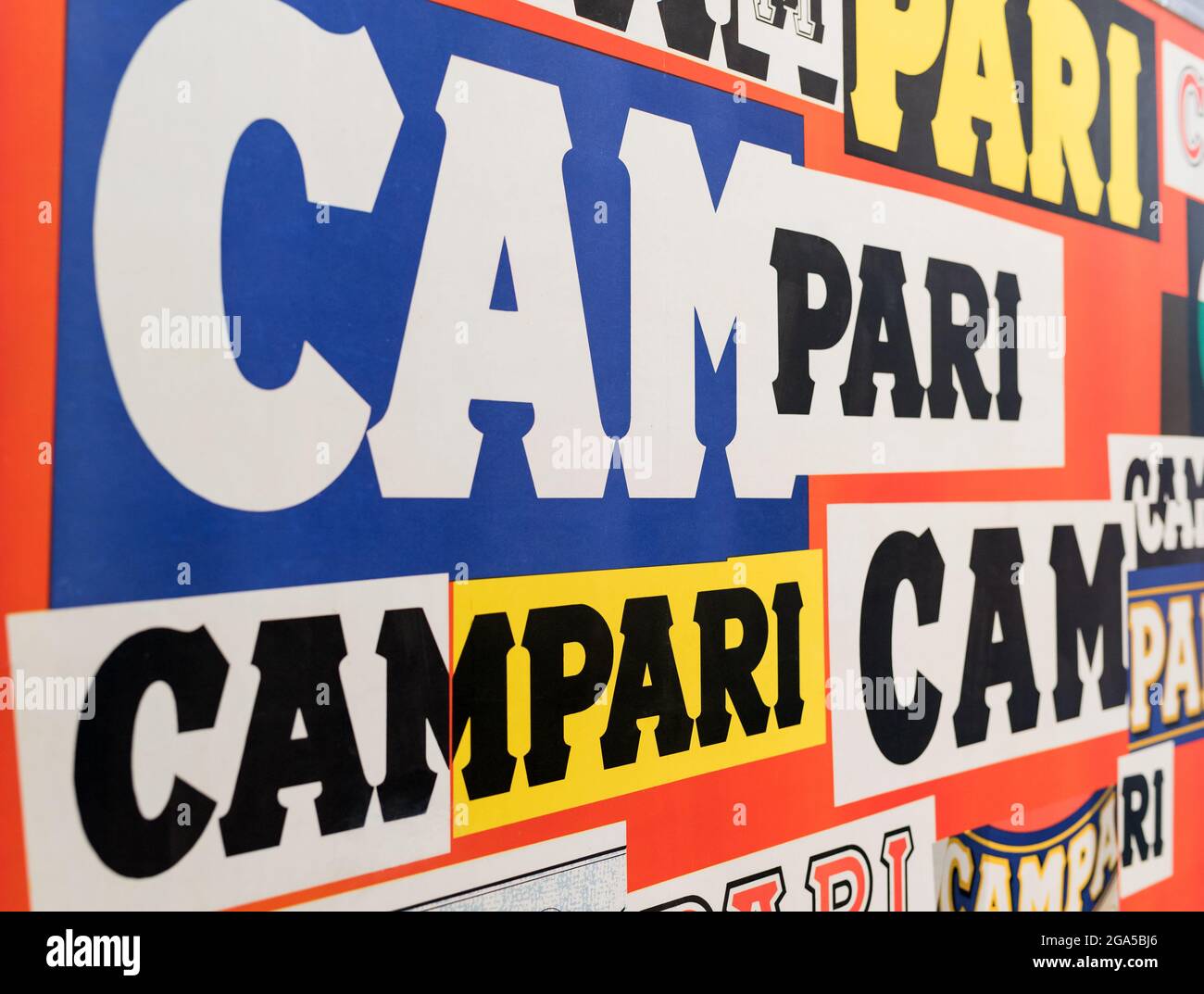 Logo italiano Campari vintage multicolore visto ad angolo obliquo con testo su sfondi colorati Foto Stock