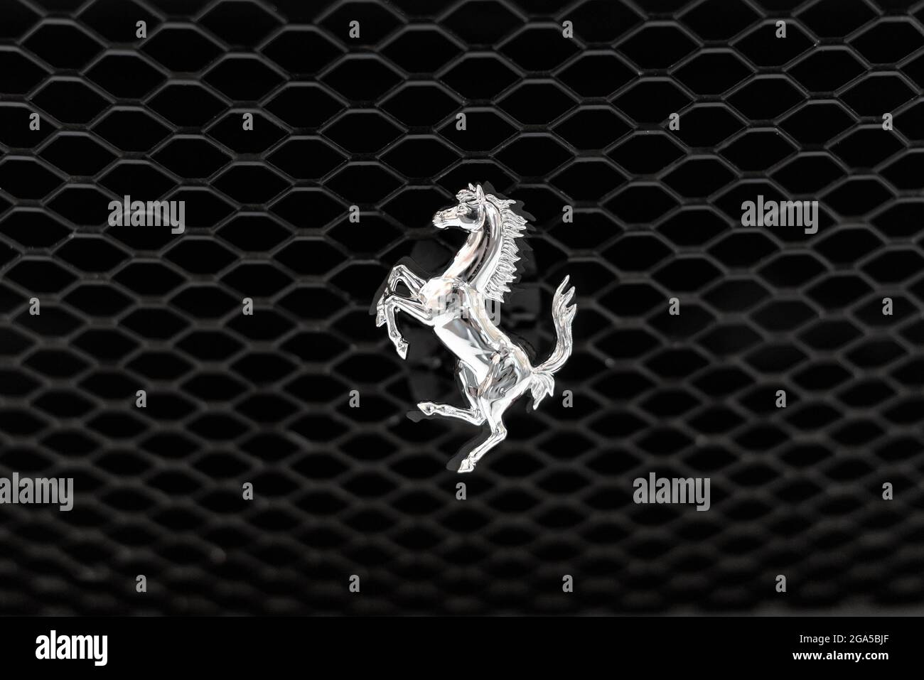 Iconico logo del Cavallo Prancing in argento metallizzato lucido di Ferrari su una griglia nera per auto con copyspace Foto Stock