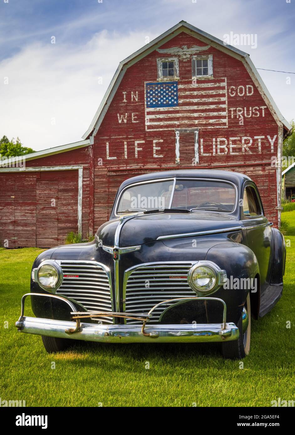 Auto d'epoca di fronte al fienile "in god we Trust" a Latah, una città della contea di Spokane, Washington, Stati Uniti Foto Stock