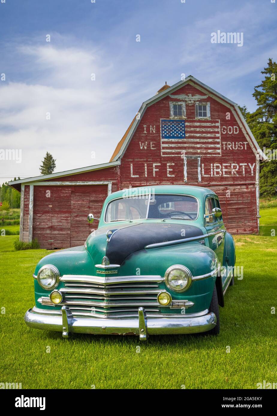 Auto d'epoca di fronte al fienile "in god we Trust" a Latah, una città della contea di Spokane, Washington, Stati Uniti Foto Stock