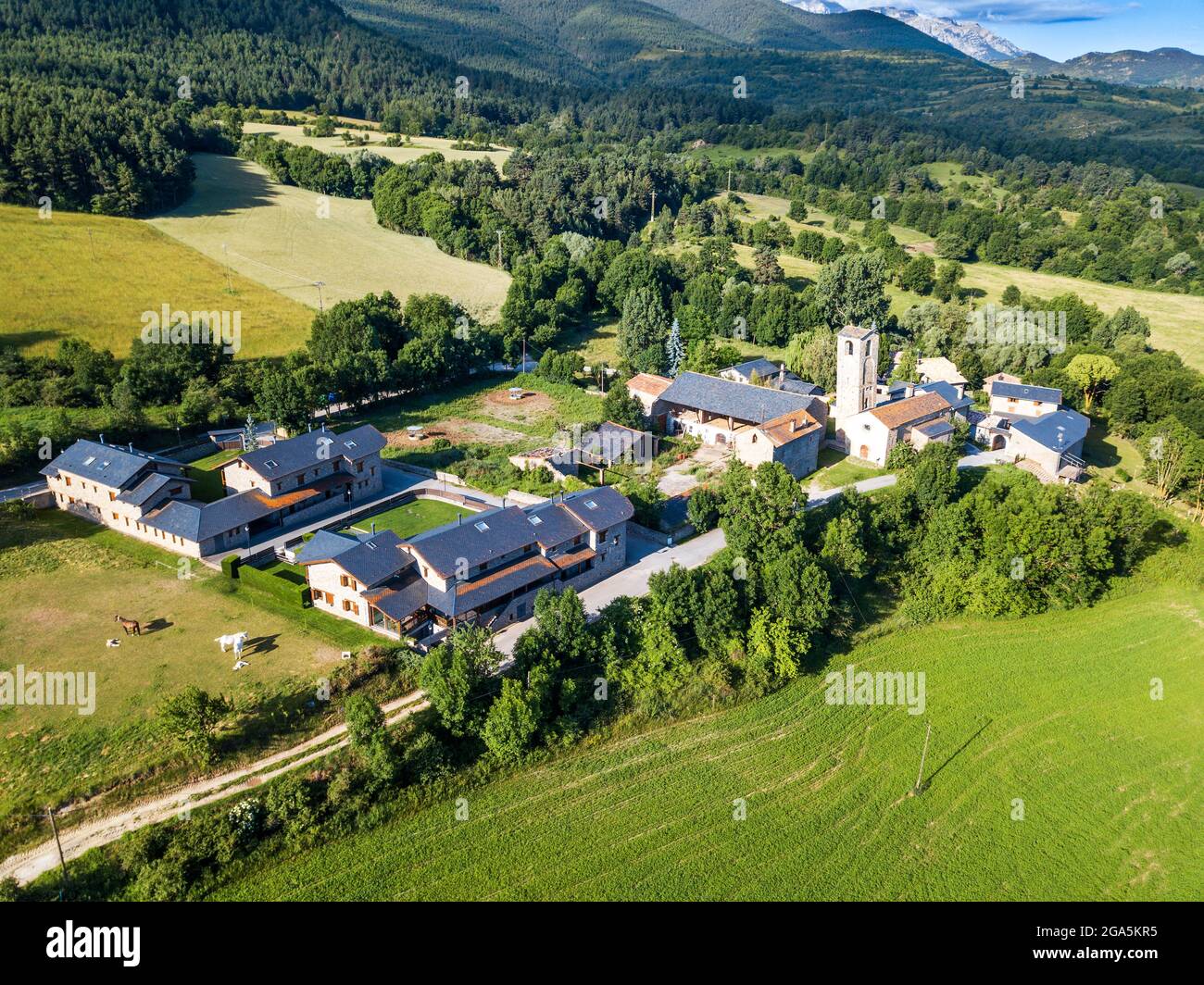 Veduta aerea della chiesa di Santa Eugènia de Nerellà a Bellver de Cerdanya Alp Pirineu Lleida provincia Catalogna Spagna. Tra le case tradizionali in Foto Stock