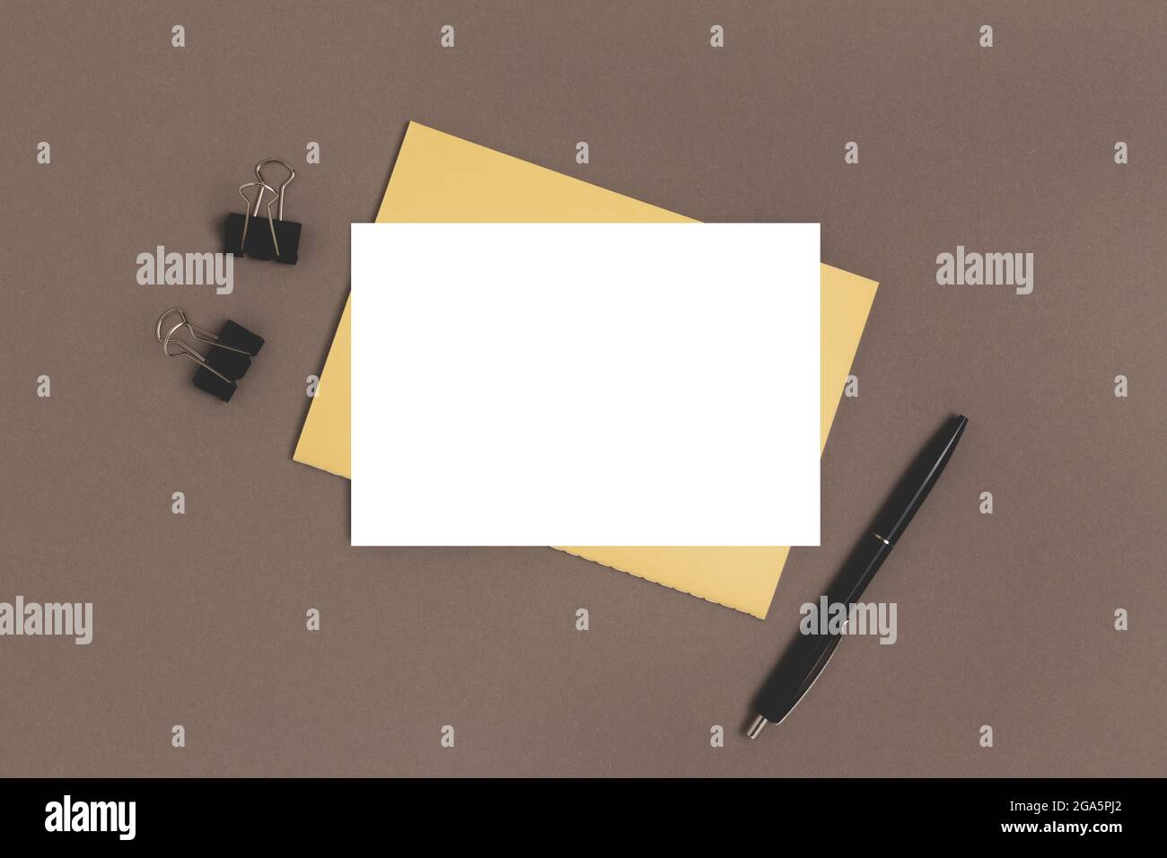 Carta vuota mockup e cancelleria su sfondo marrone. Area di lavoro documenti cartacei. Foto Stock