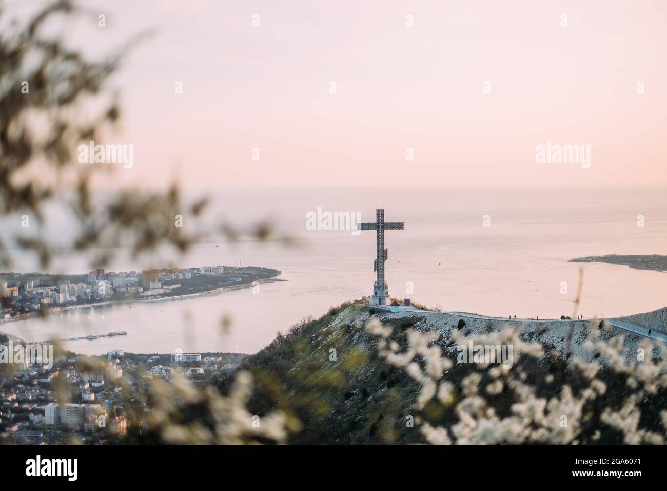 Croce ortodossa sul crinale di Markotkh. Un albero fiorito in primo piano. Foto Stock