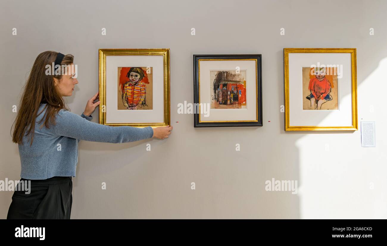 The Scottish Gallery, Edimburgo, Scozia, Regno Unito, 29 luglio 2021. Edinburgh Art Festival: Nella foto: Amy, un intern alla Scottish Gallery, con alcuni dipinti dei bambini di Joan Eardley. Una nuova mostra del noto artista scozzese Joan Eardley apre nel mese di agosto come parte del festival artistico di Edimburgo in omaggio al centenario della sua nascita nel 1921 Foto Stock