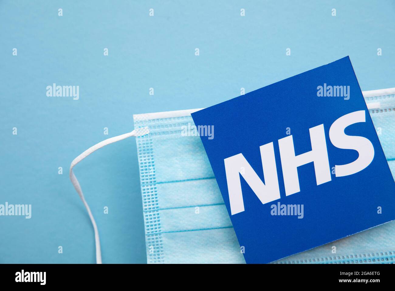 LONDRA, UK - Luglio 2021: Logo NHS National Health Service con maschera covid Foto Stock