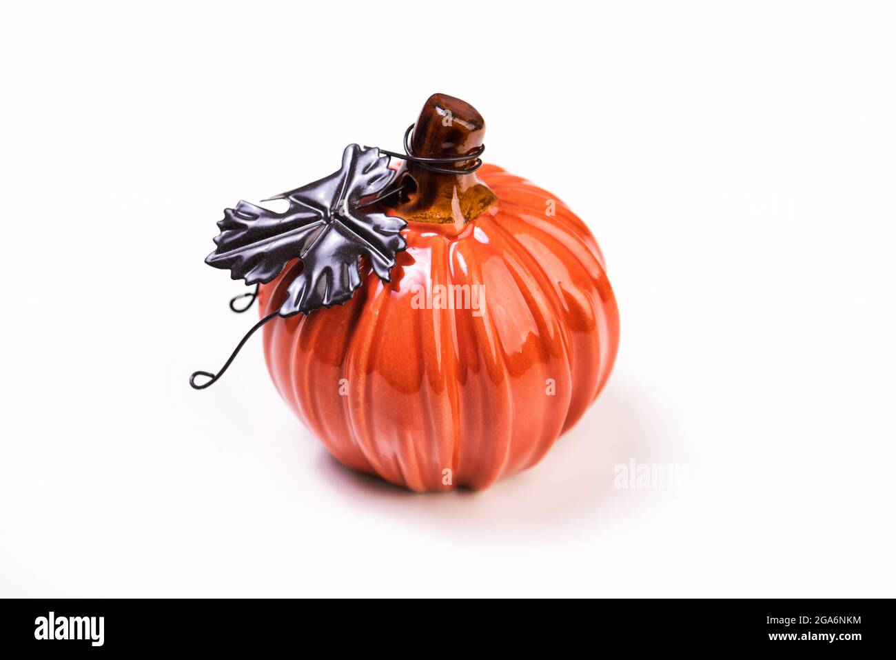 Zucca decorativa in ceramica su sfondo bianco. Zucca arancione per il Ringraziamento o Halloween Foto Stock