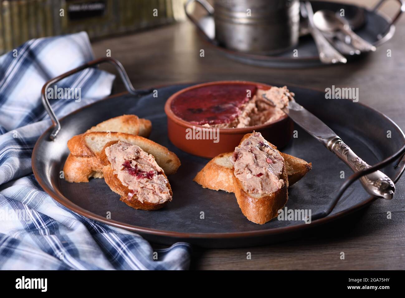 Delicato pato di pollo con purè di mirtilli spalmato su fette di baguette tostate. Cibo di stile country. Foto Stock