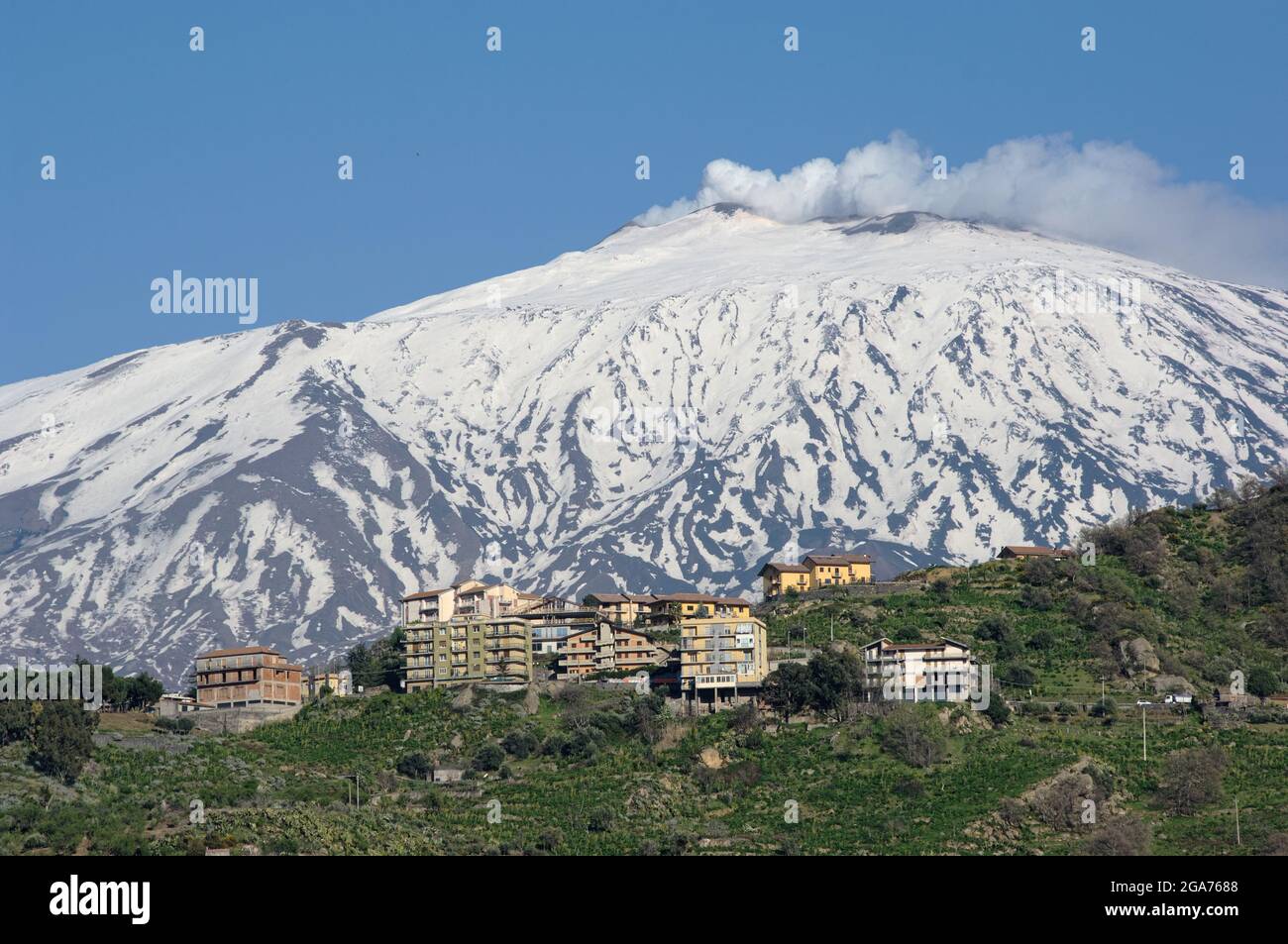 Città di montagna in Sicilia case di Bronte sotto l'attivo vulcano Etna neve coperta Foto Stock