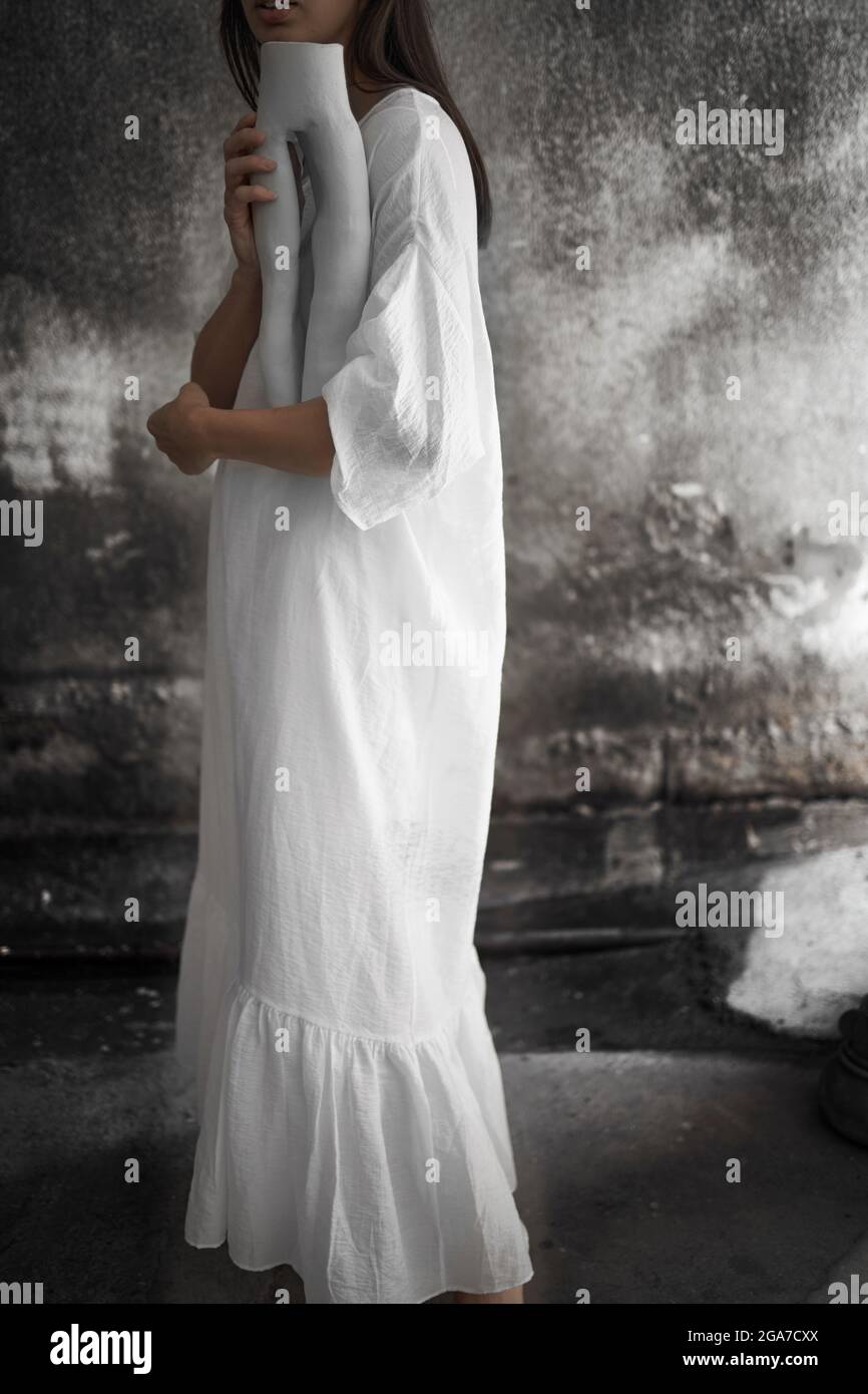 Artista femminile in un abito tradizionale che tiene il suo pezzo d'arte Foto Stock