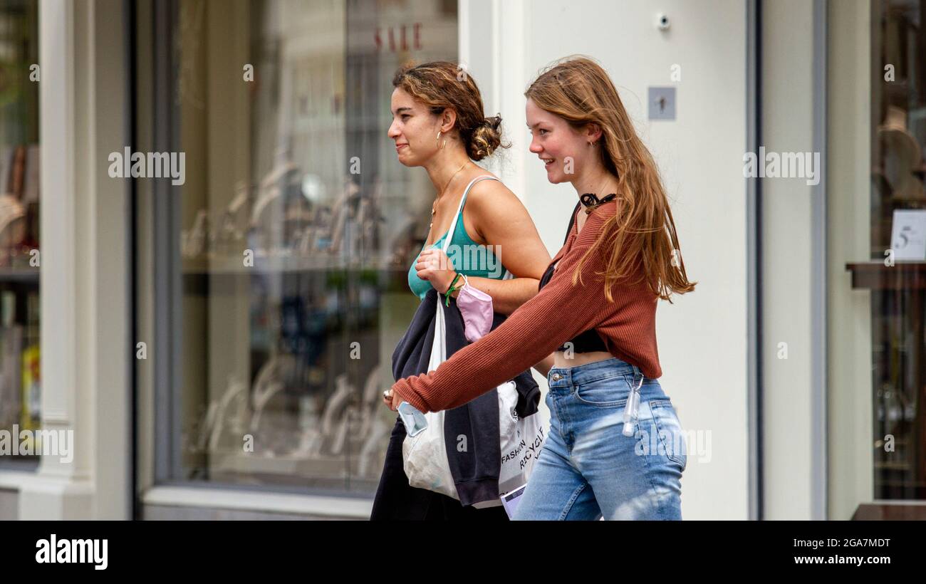 Dundee, Tayside, Scozia, Regno Unito. 29 luglio 2021. Regno Unito Meteo: Una giornata umida con incantesimi soleggiati in tutto il Nord-Est della Scozia con temperature che raggiungono i 21°C. Giovani donne alla moda che trascorrono il tempo insieme divertendosi mentre si fanno acquisti nel centro della città di Dundee dopo una notte di tempeste e pioggia torrenziale. Credit: Dundee Photographics/Alamy Live News Foto Stock