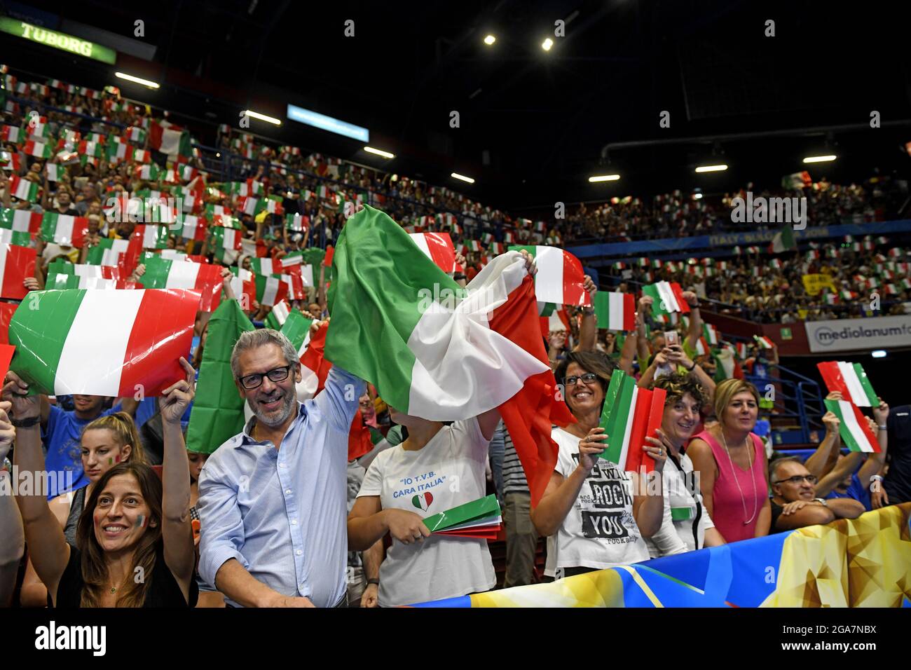 I tifosi italiani che salutano e sventolano bandiere italiane nell'arena indoor Forum, durante il Campionato del mondo di Pallavolo maschile, a Milano. Foto Stock
