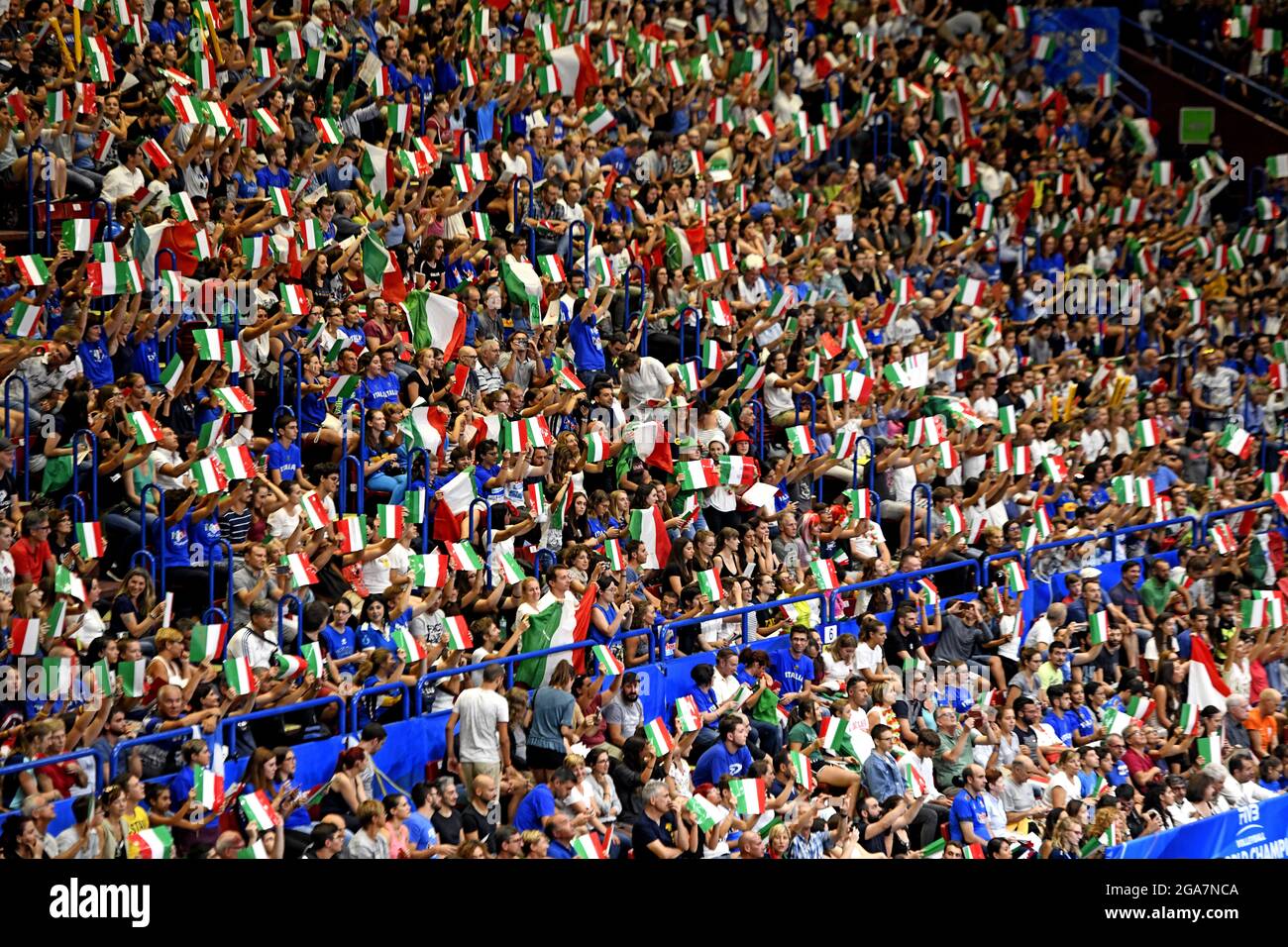 I tifosi italiani che salutano e sventolano bandiere italiane nell'arena indoor Forum, durante il Campionato del mondo di Pallavolo maschile, a Milano. Foto Stock