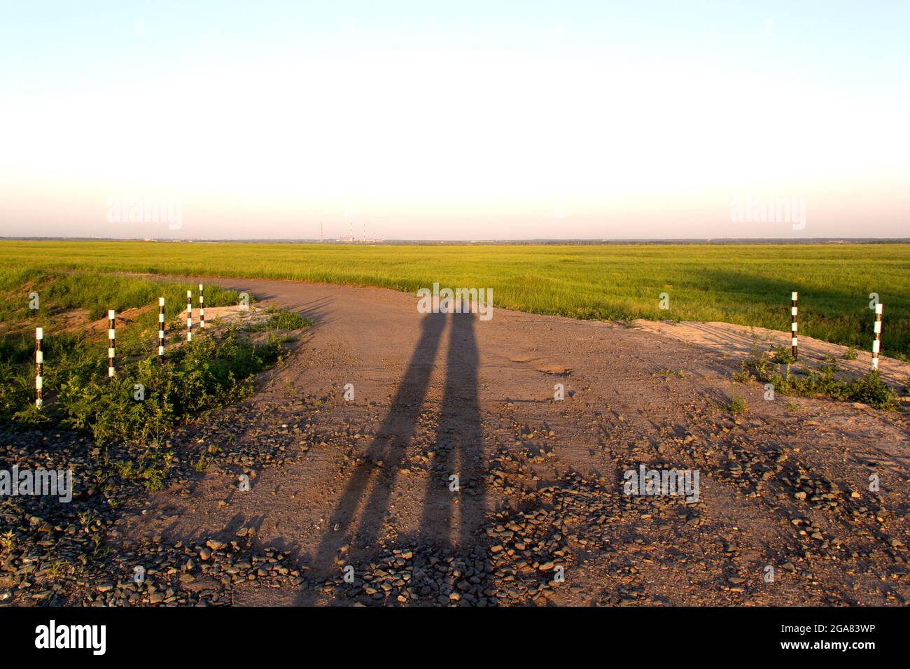 Due lunghe ombre da persone su una strada sterrata Foto Stock