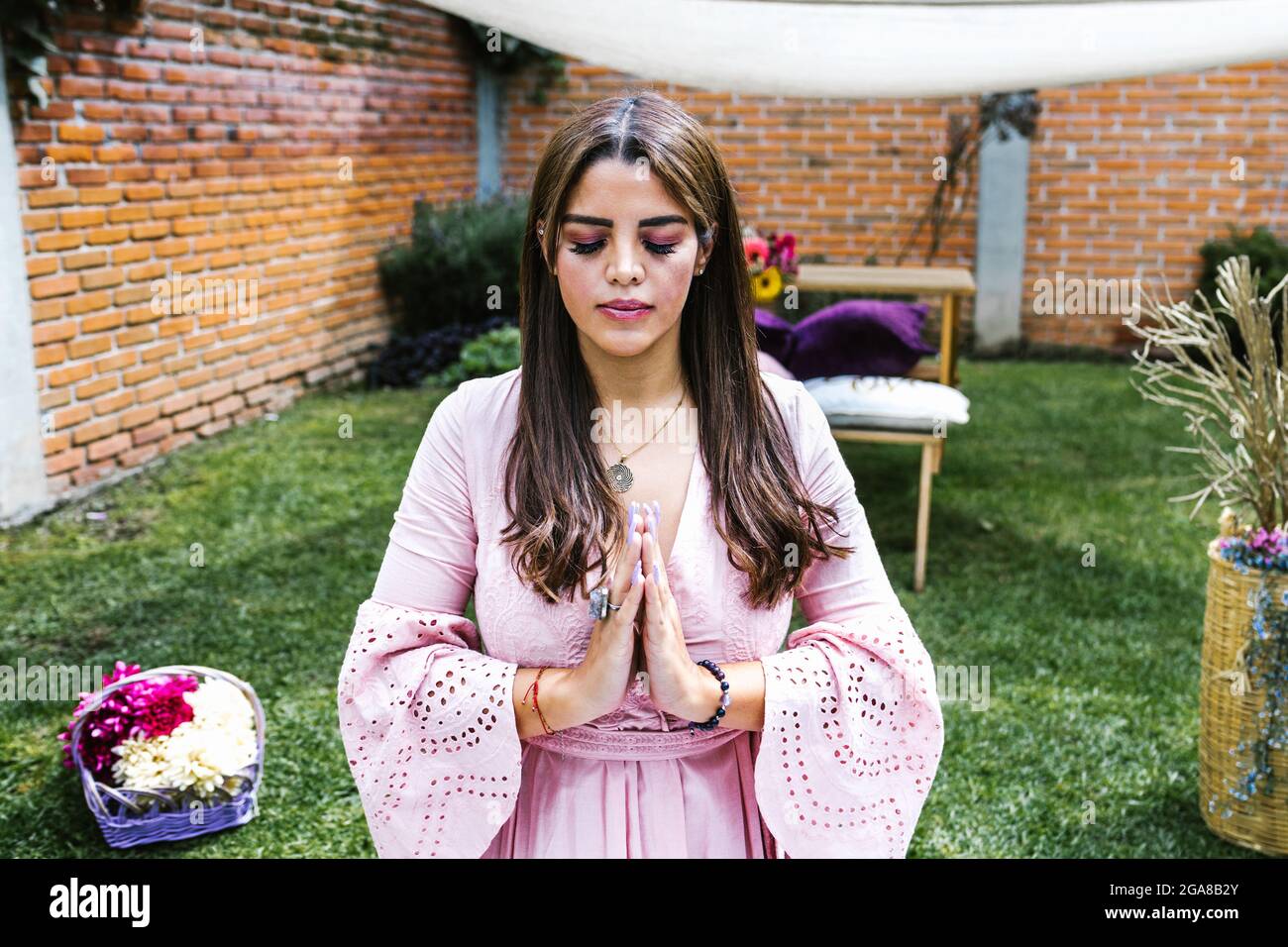 Ritratto di ragazza latina meditando con gli occhi chiusi in una sessione di terapia olistica Foto Stock
