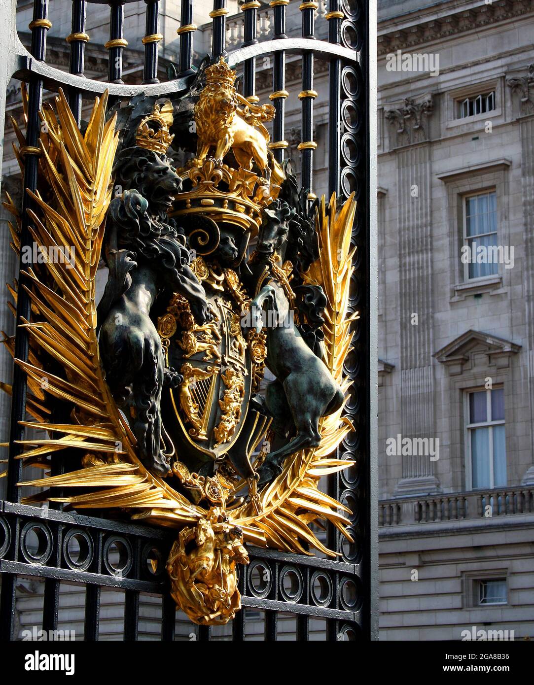 Il sole splende sul Royal Coat of Arms del Regno Unito sulla porta aperta di Buckingham Palace Foto Stock