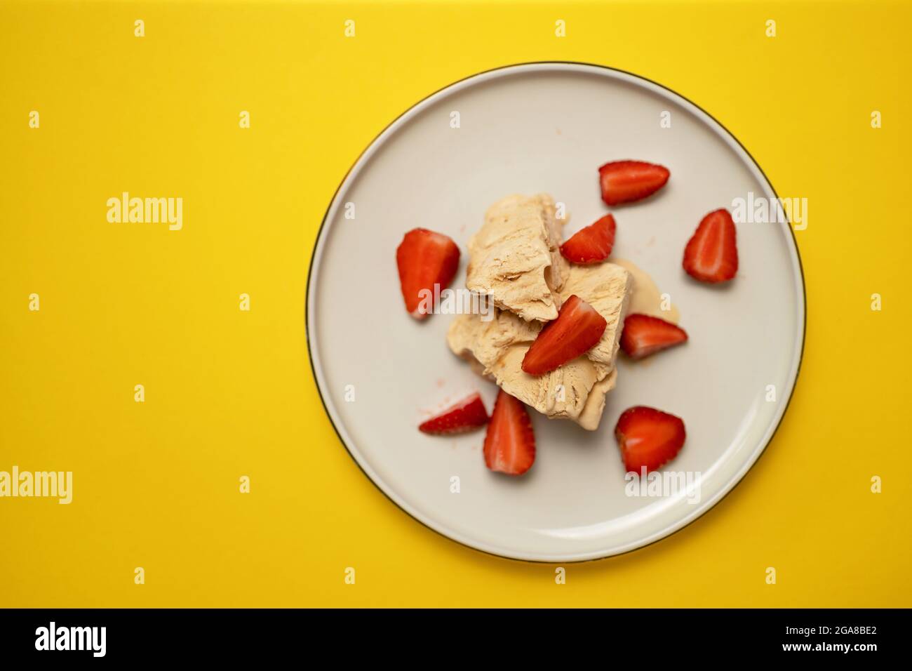 Gelato congelato fruttato con fragola su sfondo giallo, vista dall'alto Foto Stock