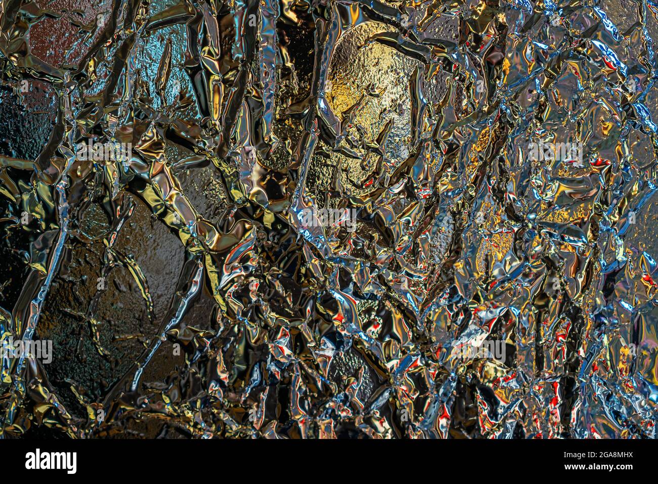 Sfondo astratto colorato e struttura di lamina metallica sminuzzata, rughe, riflessi scenici colorati Foto Stock