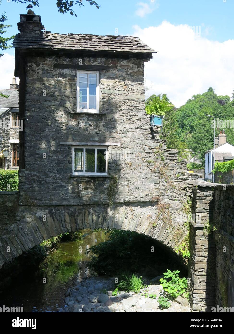 Uno degli edifici più rappresentativi del Lake District, la Little Bridge House costruita sul fiume Stock Beck risale al 17 ° secolo, Ambleside. Foto Stock