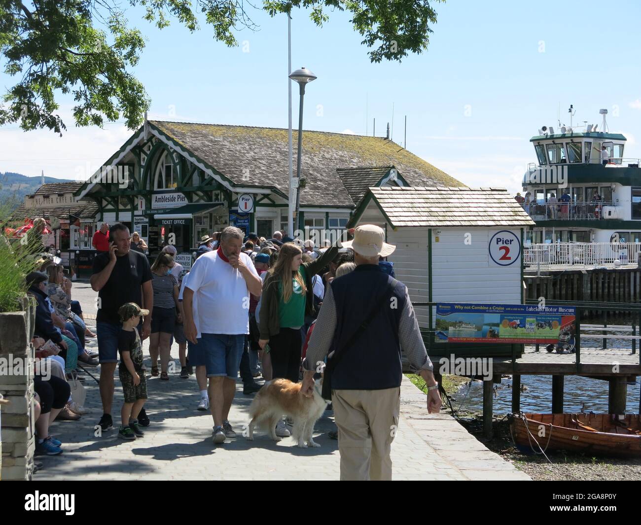 I passeggeri si accodano per il traghetto sul lago Windermere che naviga tra Ambleside e Bowness; una giornata estiva soleggiata in una staycation Lake District. Foto Stock