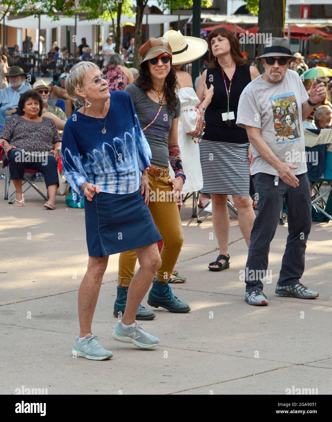 Persone di tutte le età si divertiranno a ballare con la musica di una band dal vivo che si esibisce nella storica Plaza di Santa Fe, New Mexico. Foto Stock