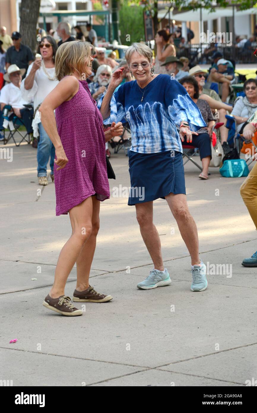 Persone di tutte le età si divertiranno a ballare con la musica di una band dal vivo che si esibisce nella storica Plaza di Santa Fe, New Mexico. Foto Stock