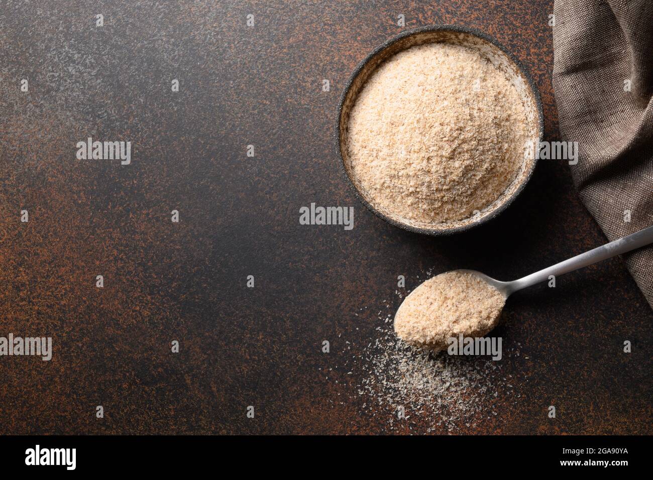 Psyllium buccia in ciotola su sfondo marrone scuro con spazio di copia. Isabgol. Superfood per panetteria senza diel e glutine, abbassa il colesterolo, bilancia il sangue Foto Stock