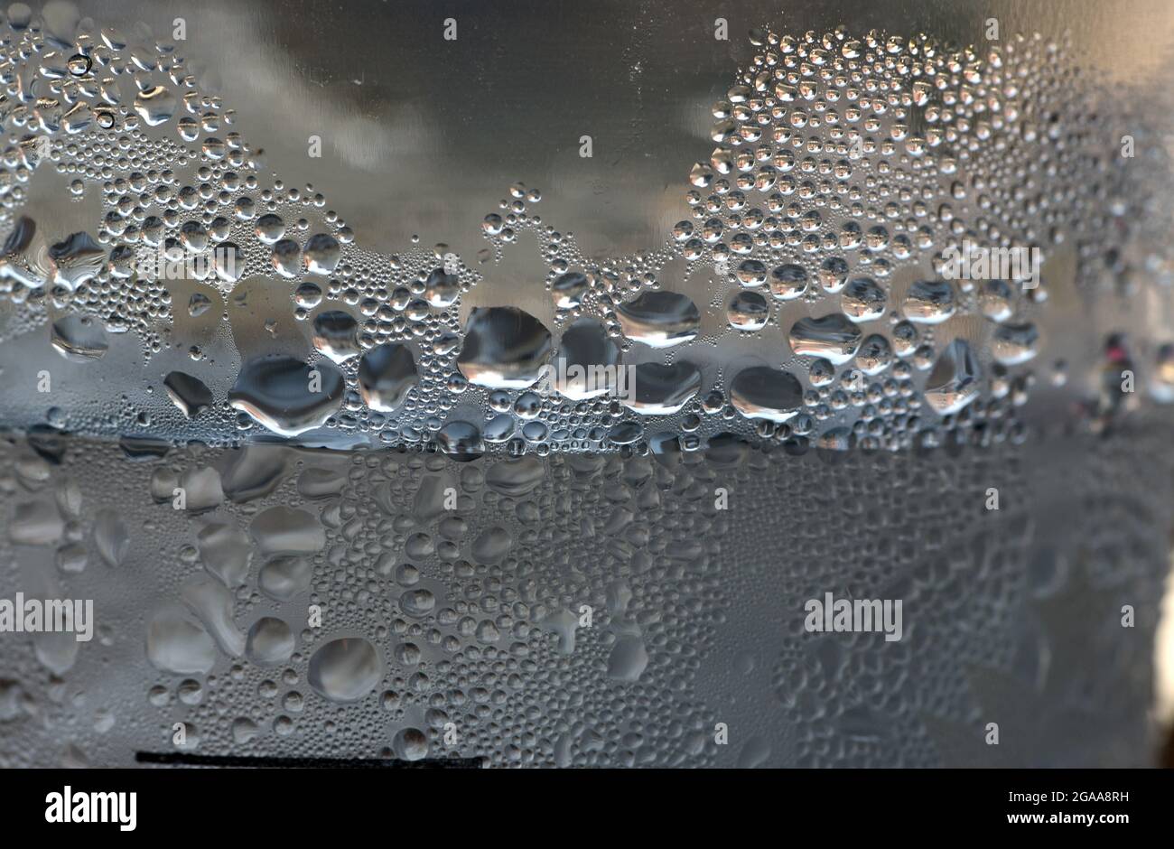Le gocce di condensa si attaccano ai lati di una tazza da bibita monouso in plastica trasparente piena di acqua ghiacciata Foto Stock