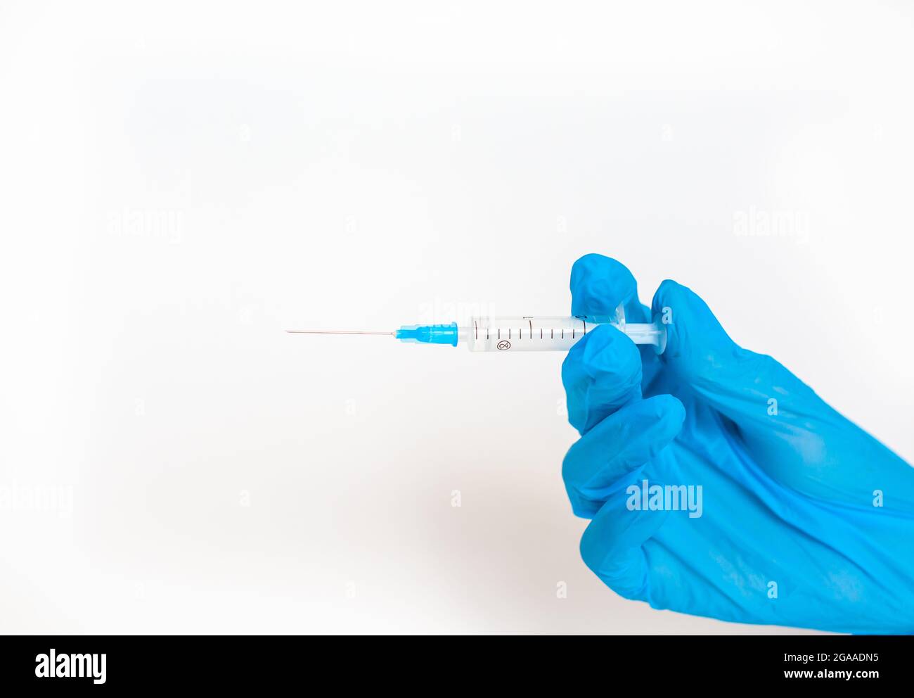 Il medico tiene una siringa di vaccinazione su sfondo bianco. Un colpo dal coronovirus. Vaccinazione contro infezioni pericolose o trattamento di di Foto Stock