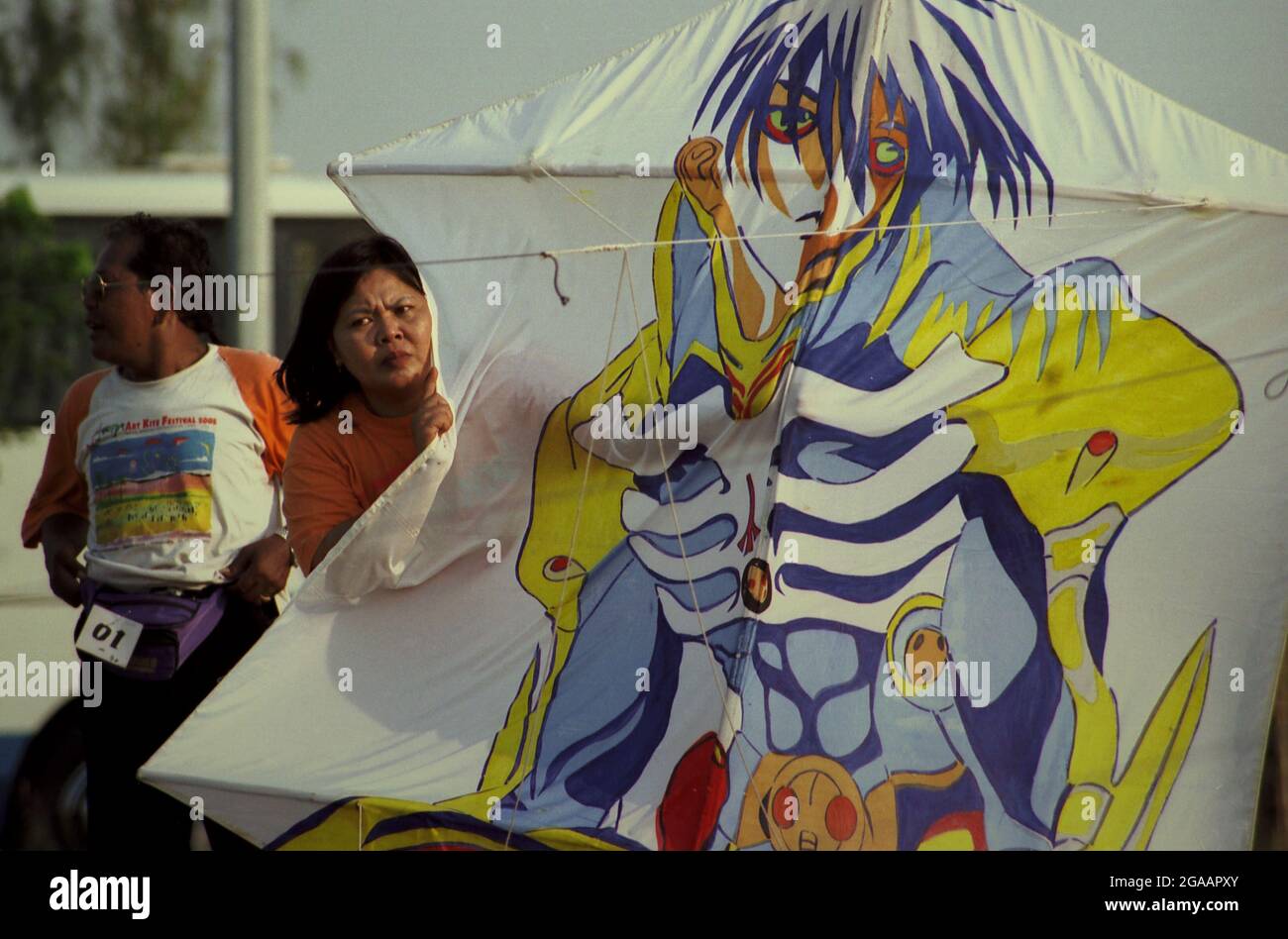 Una donna che tiene un aquilone durante il Festival Internazionale del Kite di Giacarta del 2004 che si è tenuto il 9-11 luglio a Carnival Beach ad Ancol Dreamland, Jakarta Nord, Jakarta, Indonesia. Foto Stock
