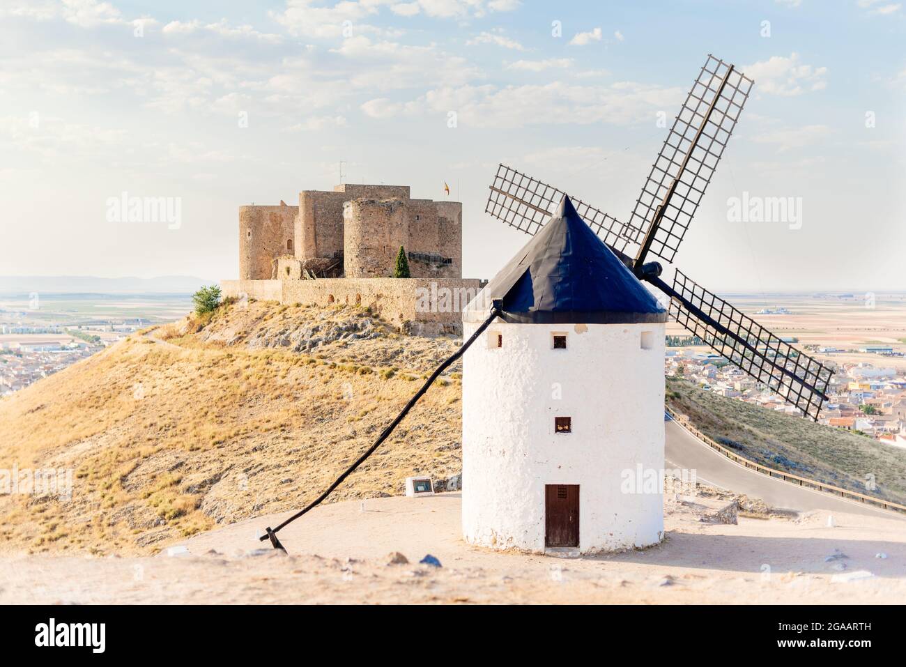Antico mulino a vento restaurato e un castello su una collina Foto Stock