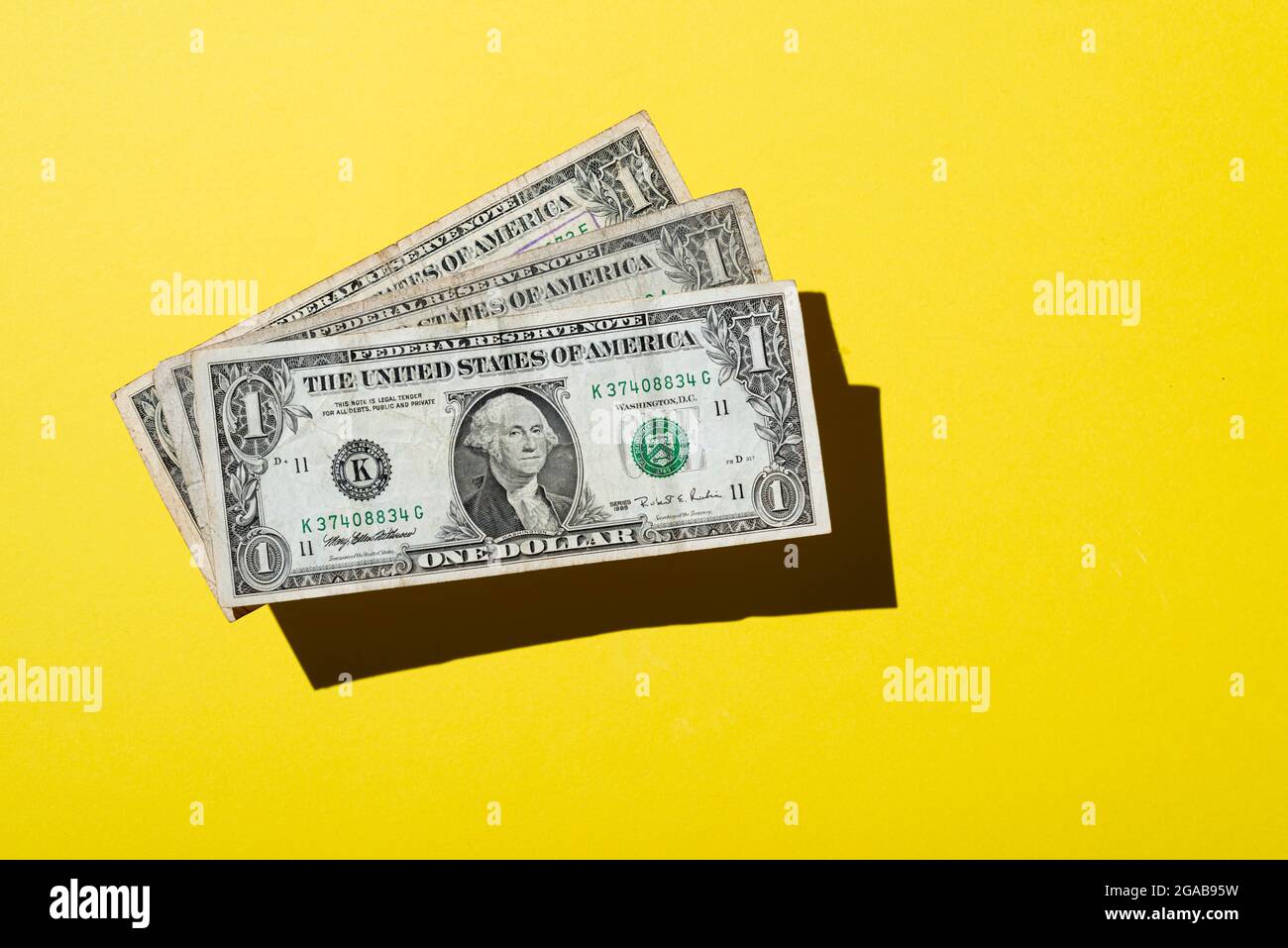 Tre 1 dollaro nota su sfondo giallo Foto Stock