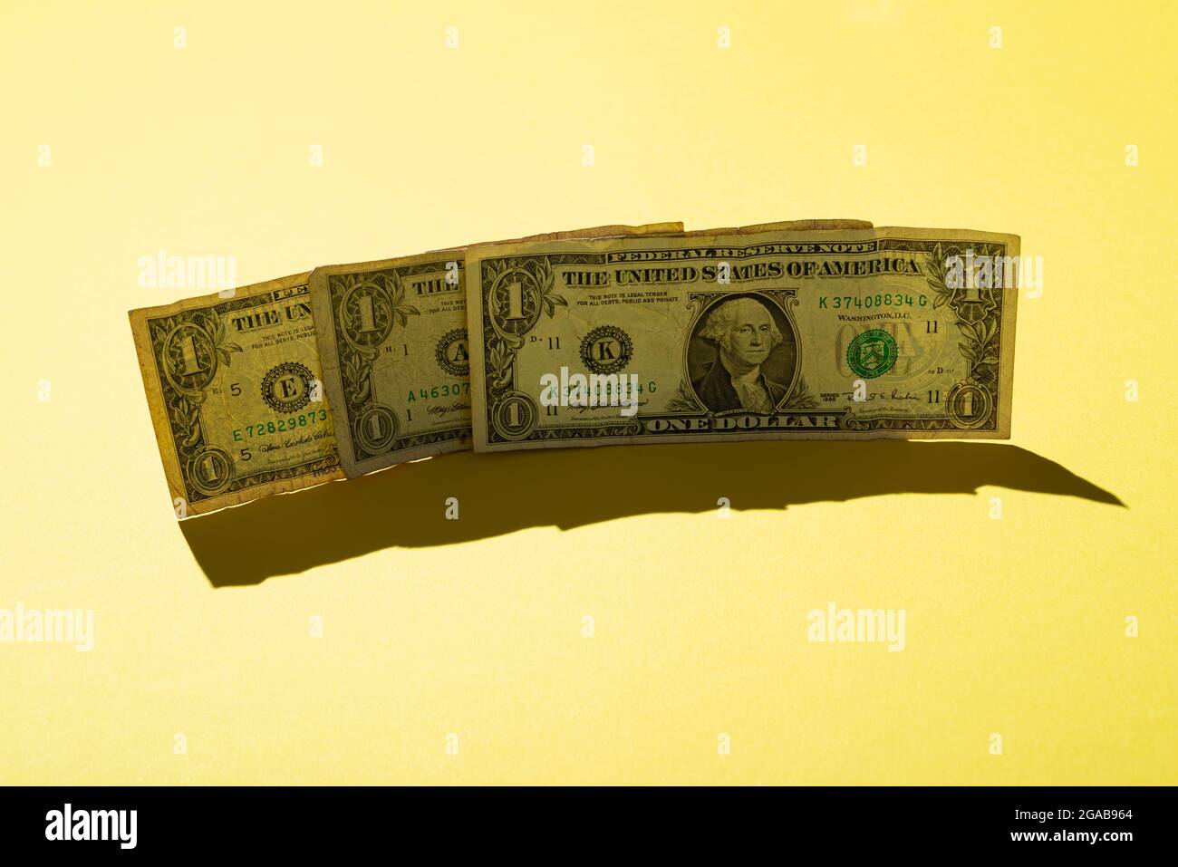 Tre 1 dollaro nota su sfondo giallo, primo piano Foto Stock