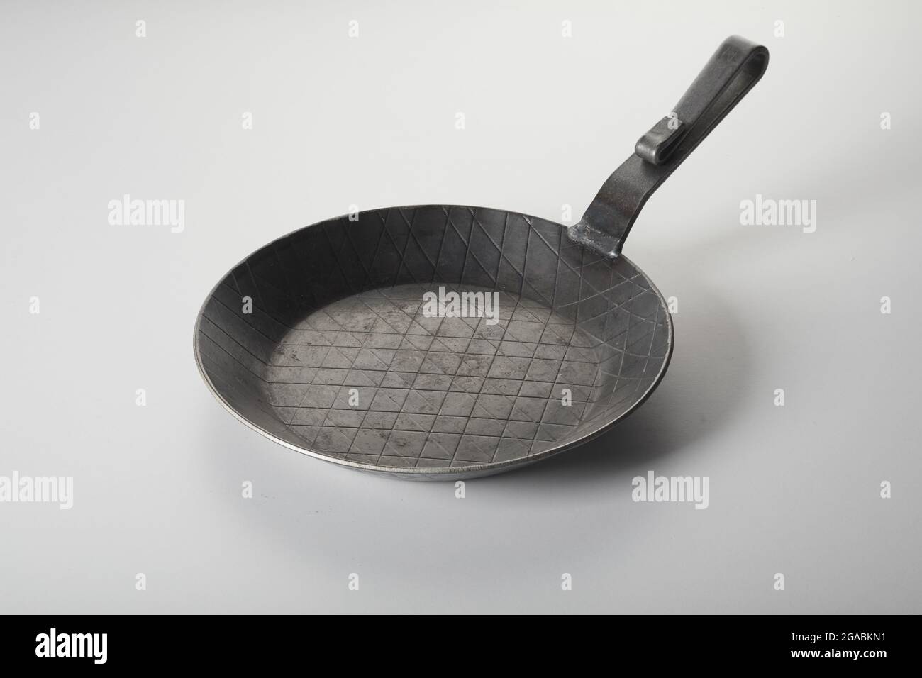 Dall'alto della vecchia padella vuota in metallo posta su sfondo bianco in cucina Foto Stock