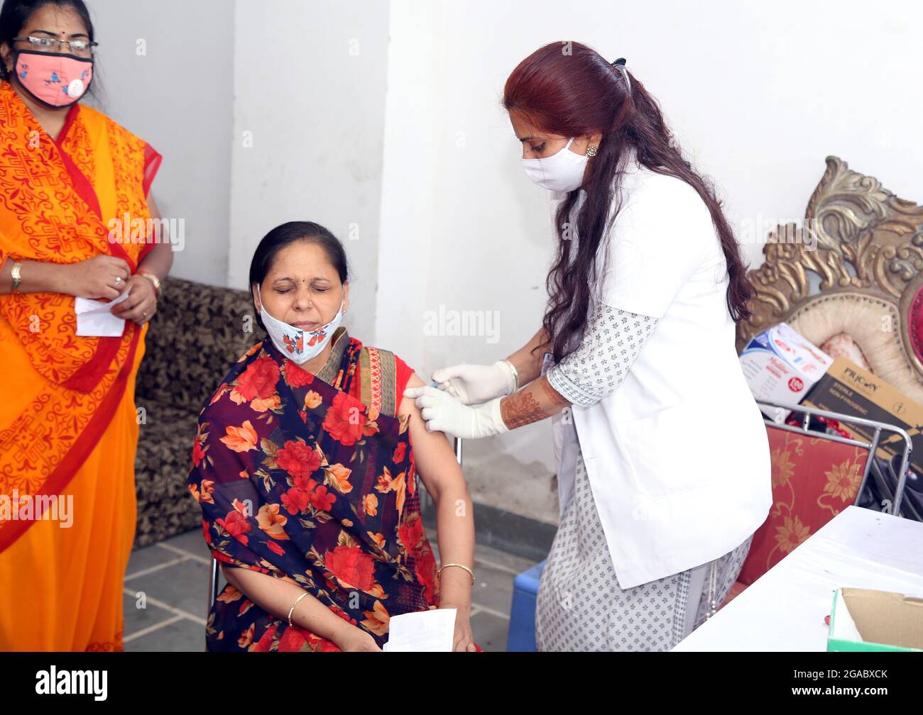 La donna indiana reagisce mentre riceve una dose di vaccino COVID-19 contro la malattia di Coronavirus durante una speciale vaccinazione di un giorno a Beawar. Più di 500 persone hanno sfrontato un centro di vaccinazione, senza allontanamenti sociali e maschere, violando tutti i protocolli COVID-19. La minaccia di un’ondata di terzo incombe, il problema della carenza di vaccini è stato segnalato in vari stati. Entro la fine di luglio, l’India non avrà l’obiettivo di somministrare oltre mezzo miliardo di dosi di vaccino corona. Ad agosto sarebbero disponibili circa 15 dosi di vaccini. (Foto di Sumit Saraswat/Pacific Press/Sipa USA) Foto Stock