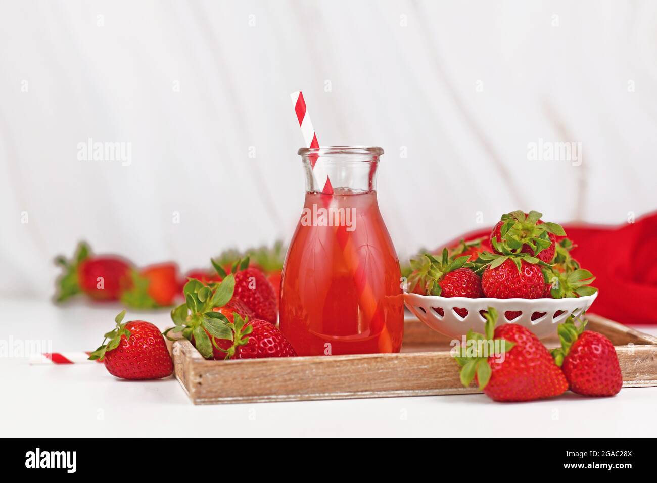 Vasetto con limonata di frutti di fragola rossa circondato da frutti di bosco Foto Stock