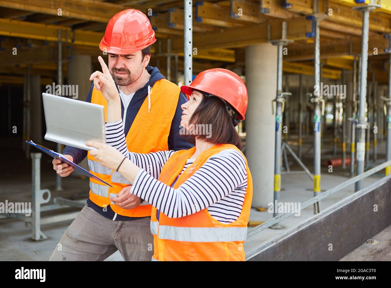 Architect with Tablet computer parla di progetto di costruzione con il caposquadra nel cantiere della shell Foto Stock